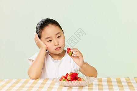小女孩看着草莓低落情绪图片
