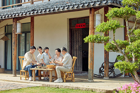 端午节坐在院子里包粽子的一家人高清图片