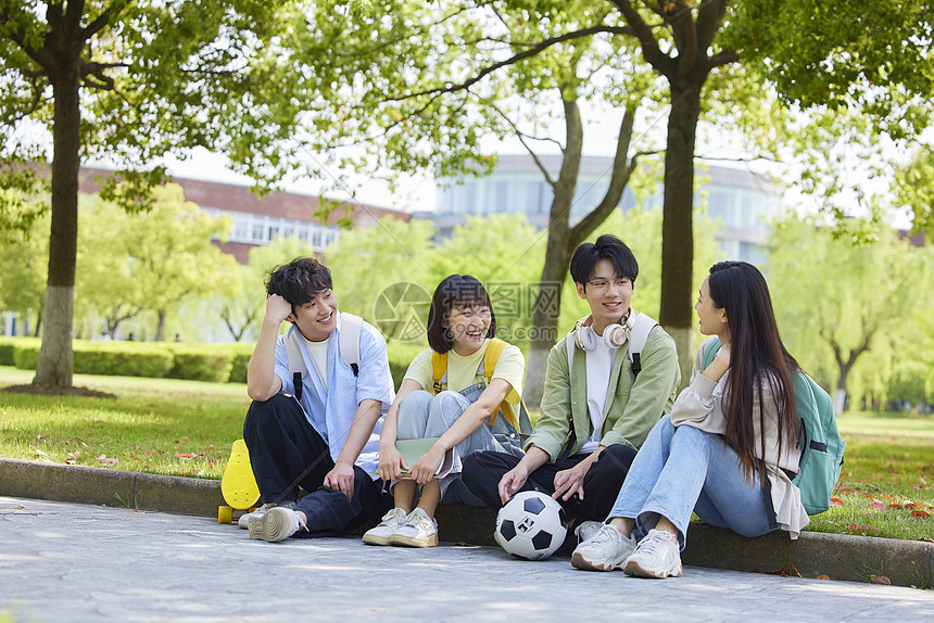 大学生们坐在校园草地边图片