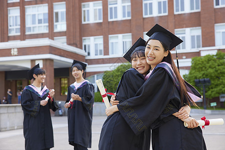 穿学士服的女大学生闺蜜拥抱图片