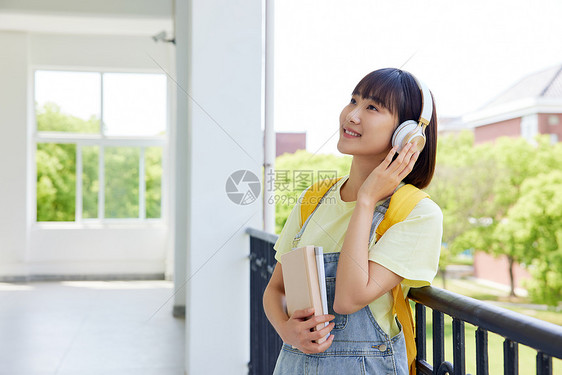 戴着耳机听音乐的大学女生图片