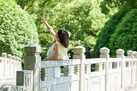 女长裙夏日清新美女公园里享受阳光背景