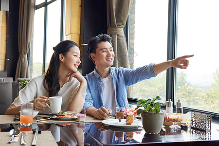 夫妻在餐厅用餐看窗外风景高清图片