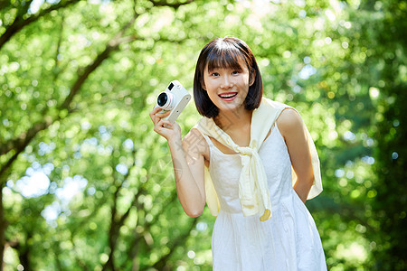 女性户外游玩手拿照相机图片