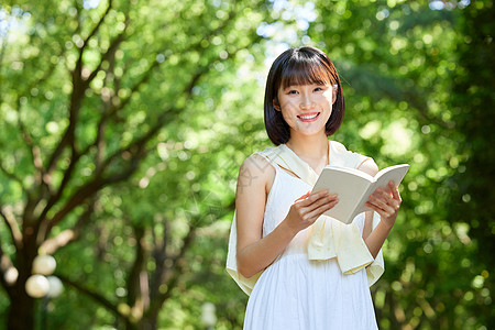 短发女生夏日户外看书的短发少女背景