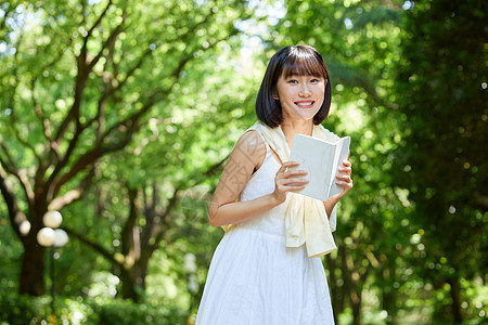 女生户外手拿书本图片