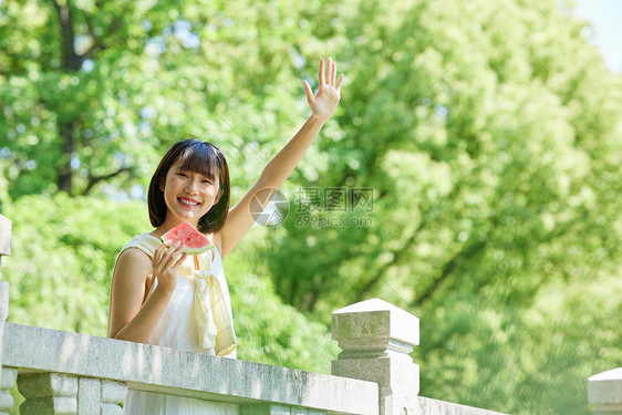 女孩夏日户外手拿西瓜打招呼图片