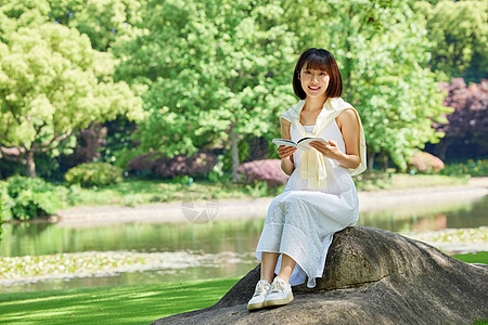 女生夏日坐在河边石头上看书形象图片