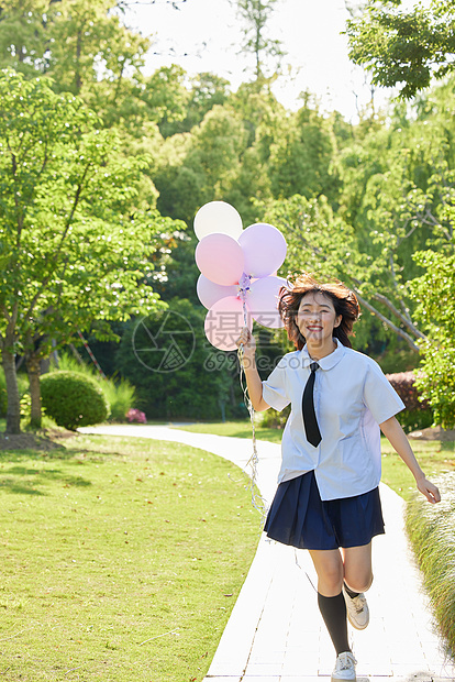 户外女学生手拿气球奔跑图片