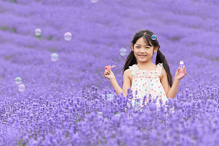 薰衣草花田里吹泡泡的小女孩图片