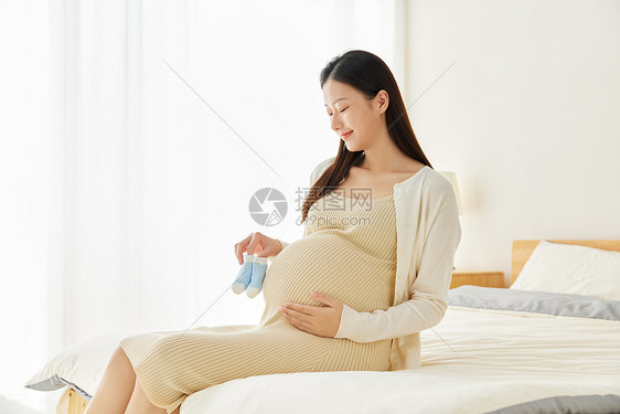孕妇妈妈手拿宝宝袜子图片