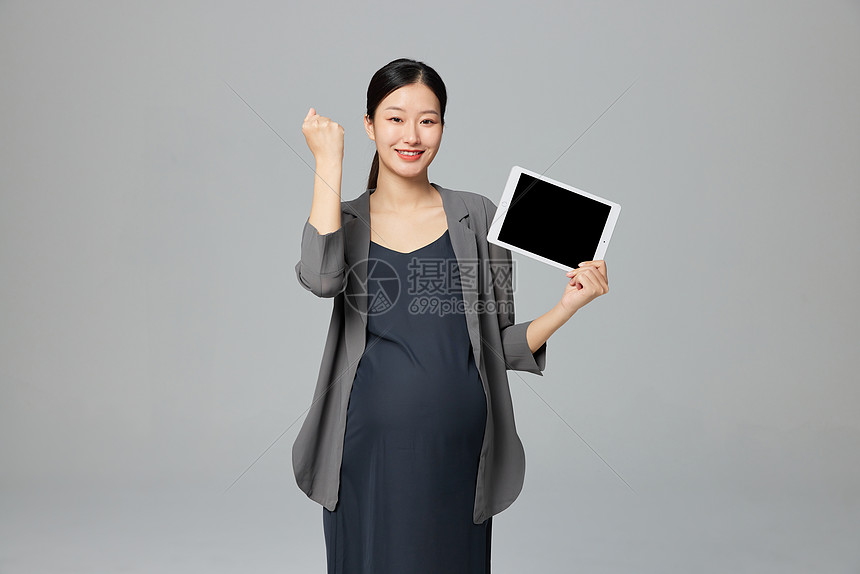职场孕妇手拿平板电脑加油手势图片