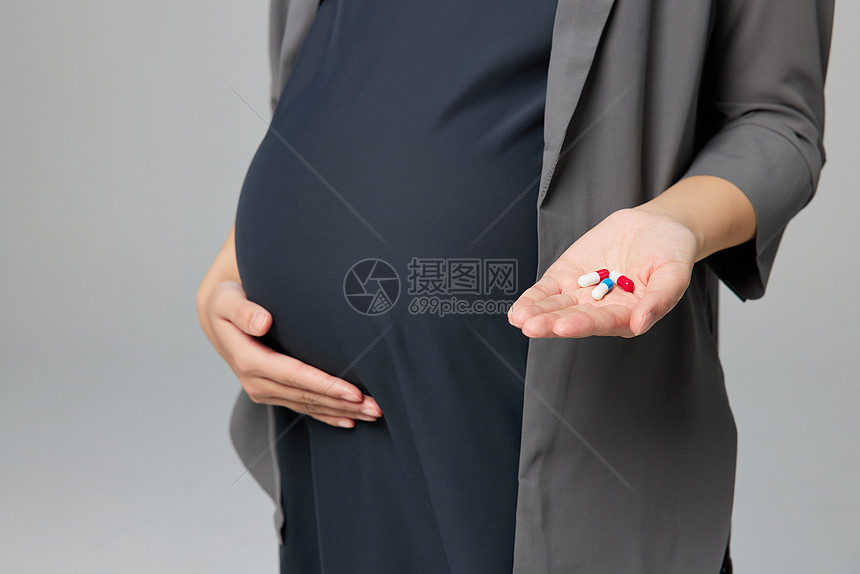 职场孕妇妈妈吃药特写图片