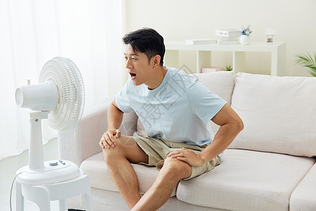 夏日居家吹风扇的男子图片