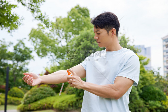 手臂喷洒驱蚊液的男人图片