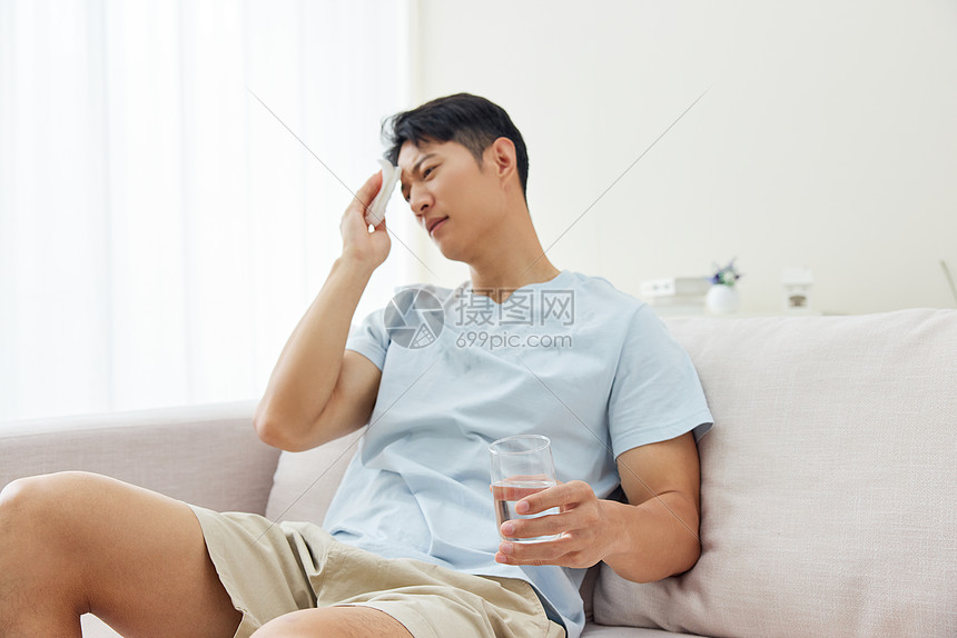 男子在沙发上擦汗喝水图片
