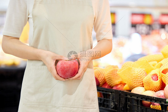 促销员手中的新鲜苹果特写图片