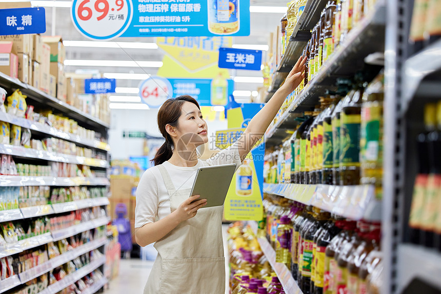 记录调味品信息的超市店员图片