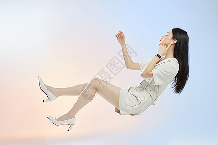 佩戴电子设备的女人悬浮在空中听音乐图片