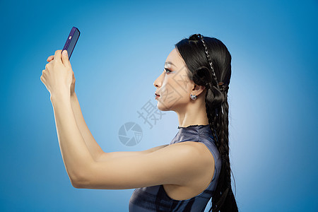 手拿智能手机的年轻女孩背景图片