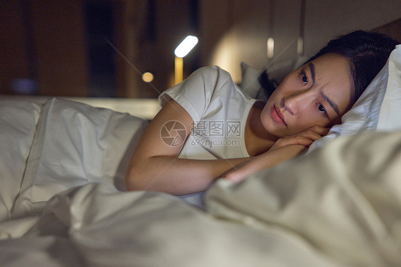 侧躺在床上失眠的女性图片