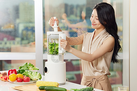 白领女性使用榨汁机榨绿色食品背景图片