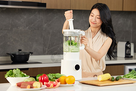 果蔬料理机白领女性使用榨汁机榨绿色果汁背景