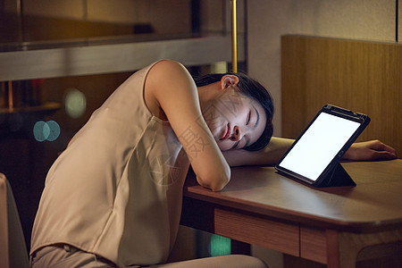 女人趴在平板电脑前睡着图片