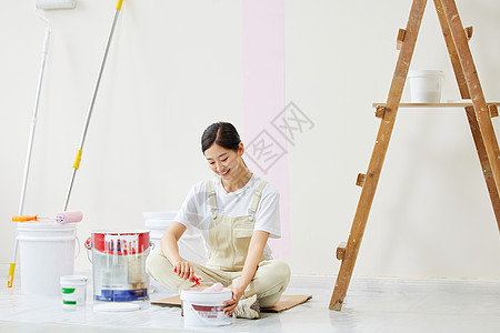 女人盘坐着调试油漆颜色高清图片