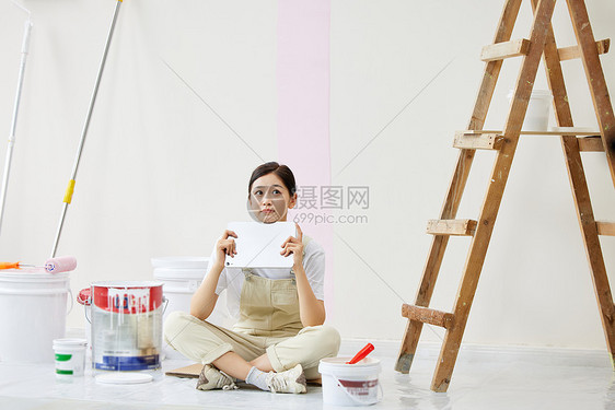 女子盘坐着构思房屋设计图片