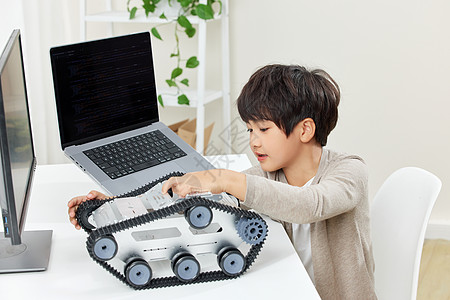 电脑桌前研究组装机器的男孩图片