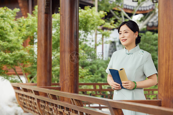 中年女性庭院中读书图片