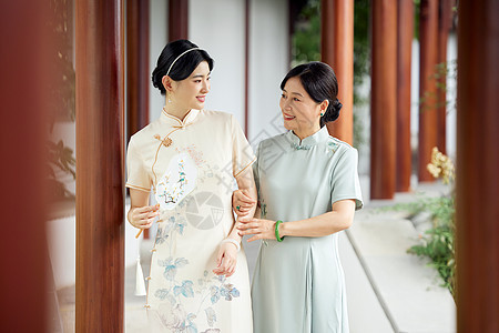 旗袍优雅母女在中式庭院散步背景图片