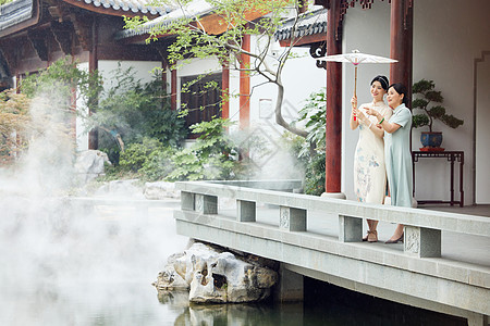 母女聊天穿旗袍的母女欣赏中式庭院雨中美景背景