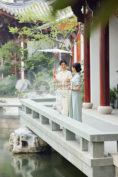 下雨天在中式庭院撑伞的旗袍母女图片