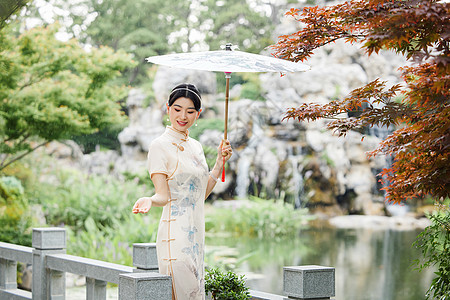 雨天撑伞在中式庭院中的旗袍女性图片