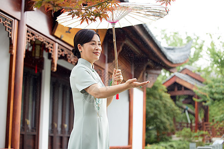 雨天撑伞在中式庭院的中年女性高清图片