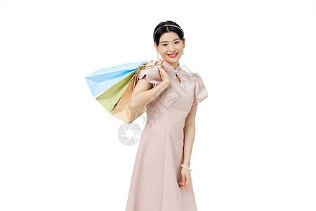 年轻女性穿着旗袍手拿购物袋图片