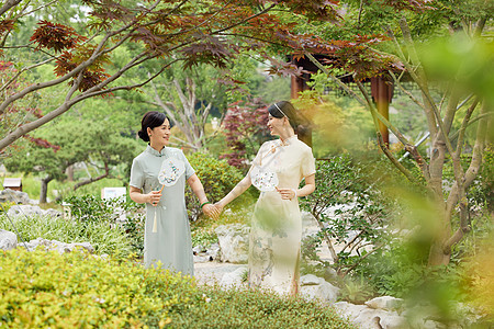 旗袍母女院子里牵手散步背景图片