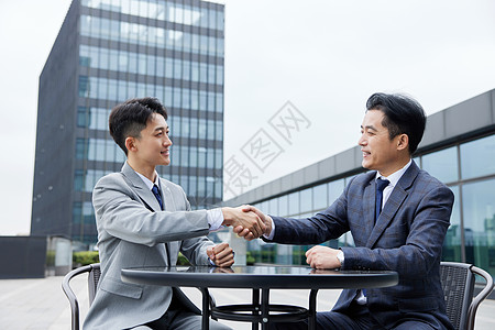 客户至上洽谈合作后握手的男人们背景