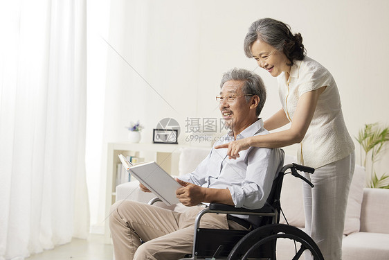 奶奶陪着轮椅上的爷爷阅读图片