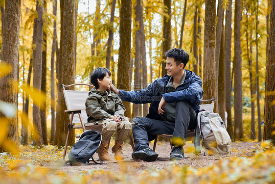 坐在树林里休息聊天的父子图片