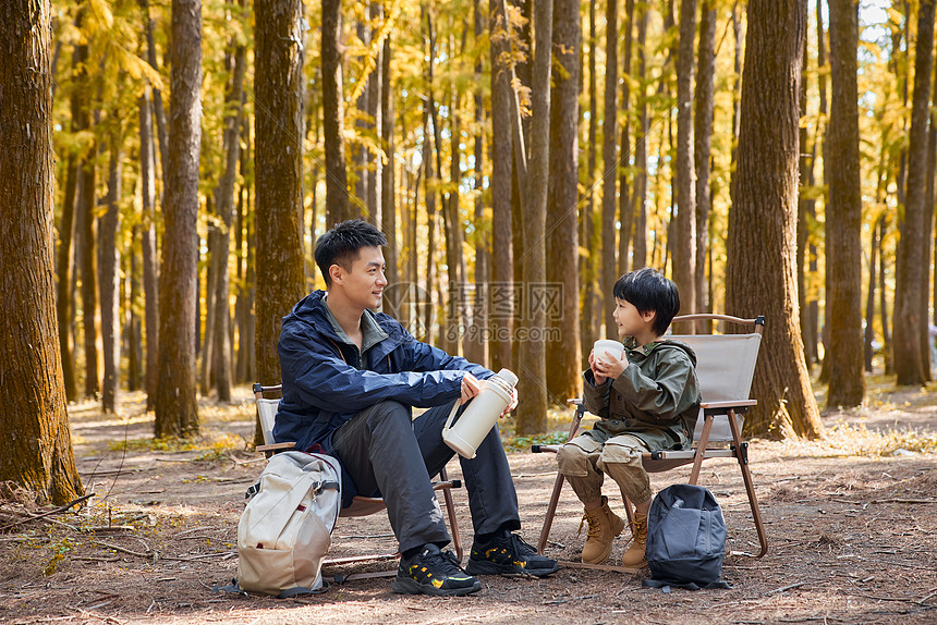 在树林里休息的野营父子图片