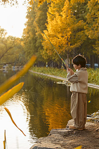 小男孩站在河边钓鱼图片