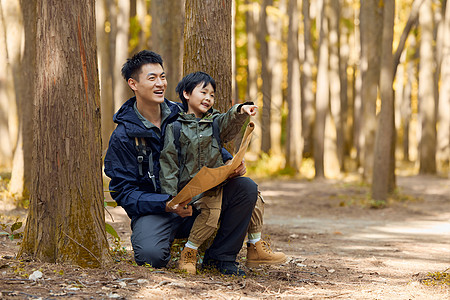 登山背景小孩坐在爸爸腿上查看地图背景