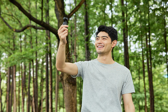 男性在公园手持录像设备图片