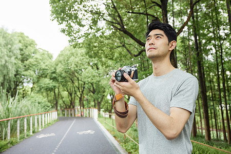 户外手拿照相机的男性图片