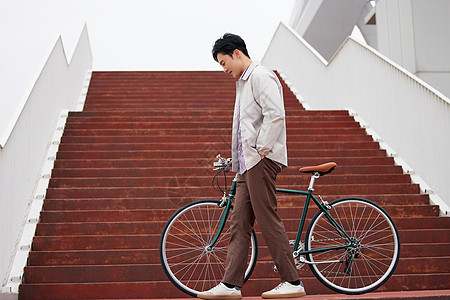 骑行图片阶梯上停车休息的男青年背景