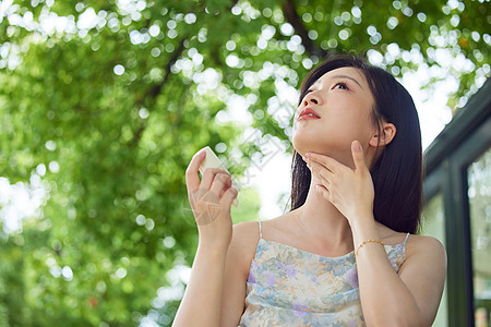 室外女性在脖子上涂抹防晒图片