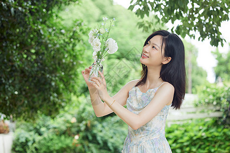 户外女生抱着玻璃花瓶图片